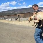 Exec Dir ohn Golay at Rescue Ranch Sanctuary in Big Springs carrying a rescued dump dog