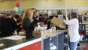 Thrift Store, customers atthe counter, Jodi packing purchases