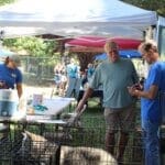 Red Dog Pet Supply Puppy Pool and Adoption Event_Rick Formanek talking with propective adopter