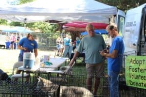 Red Dog Pet Supply Puppy Pool and Adoption Event_Rick Formanek talking with propective adopter