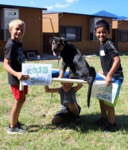 Dog socialization training camp_Rylynn, Santiago lifting Jojo on cot and friend underneath