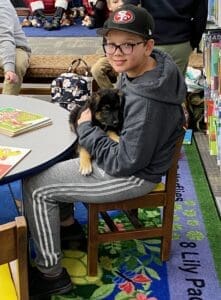 Puppies puppies puppies_Boy at table with puppy on his lap