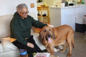 Dog Rescuers_Foster mom Colette petting Woody wide shot